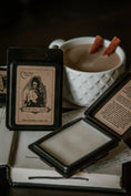 Load image into Gallery viewer, Spooky wax melt lying open against a mug of steaming chai with cinnamon sticks.