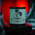 Load image into Gallery viewer, a candle showing two people kissing and they look like zombies