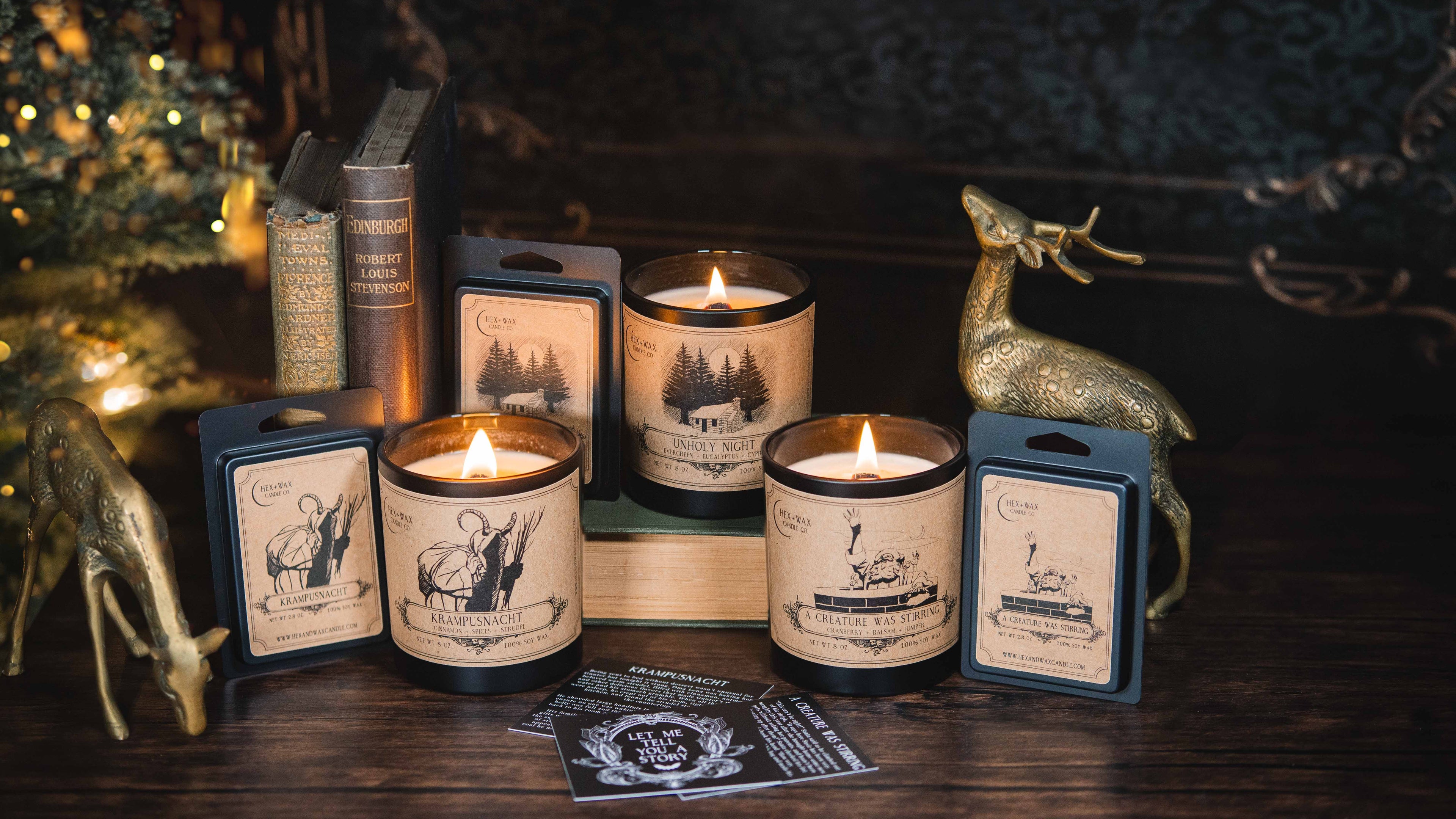 Christmas candles lit with dark holiday decorations aesthetically placed around